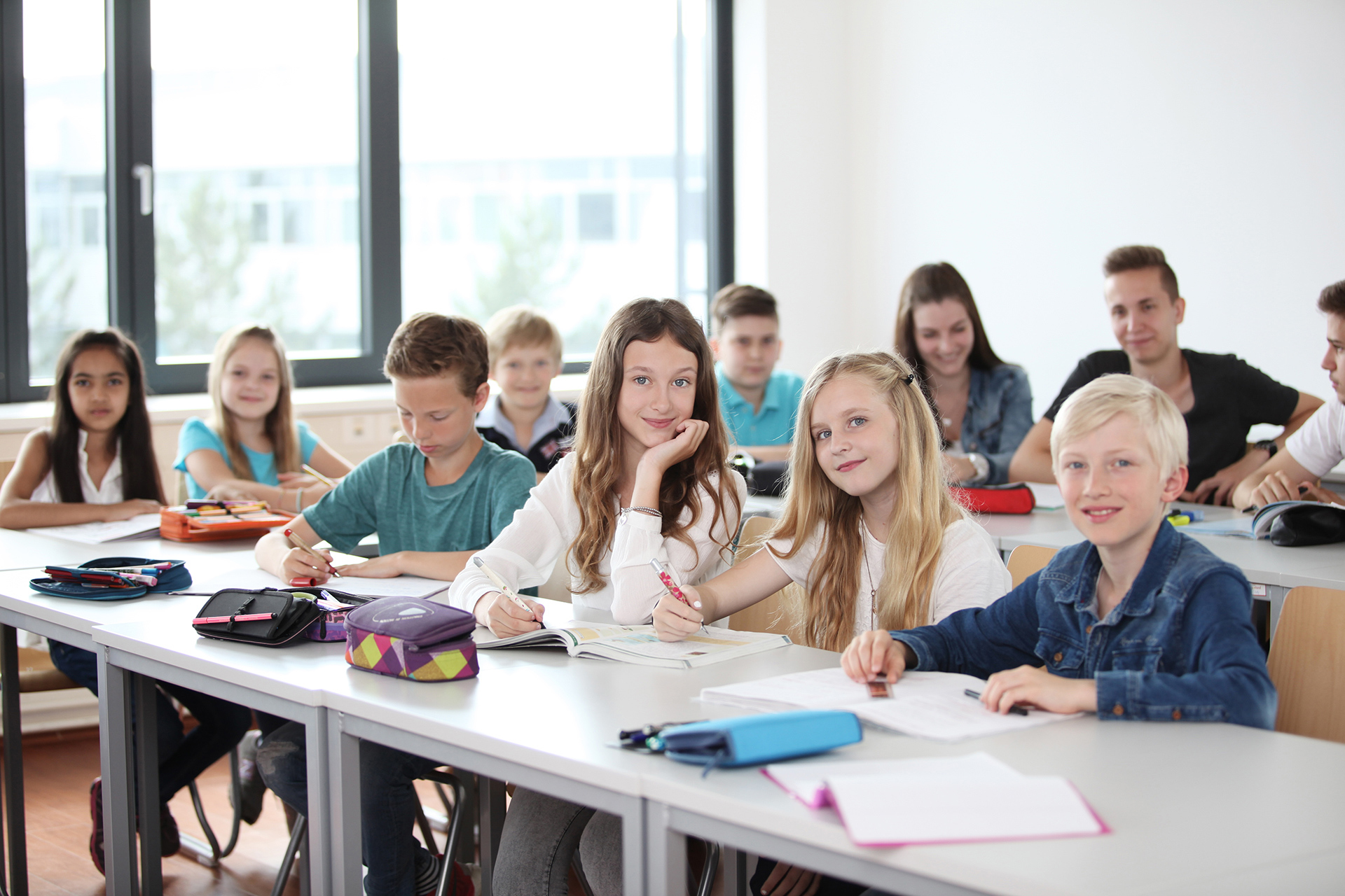Kinder sitzen im Klassenzimmer an den Tischen